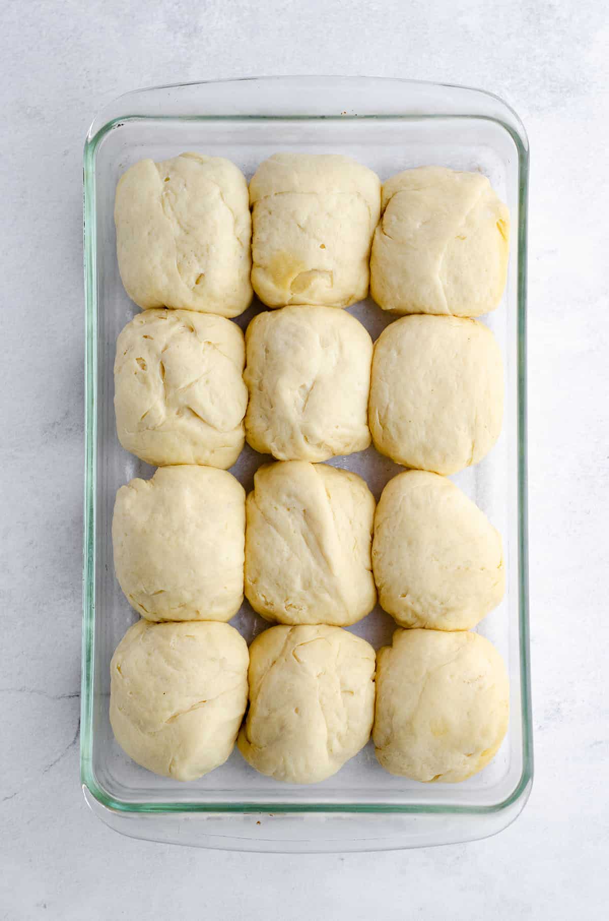 easy yeast roll dough in a glass baking dish ready to rise