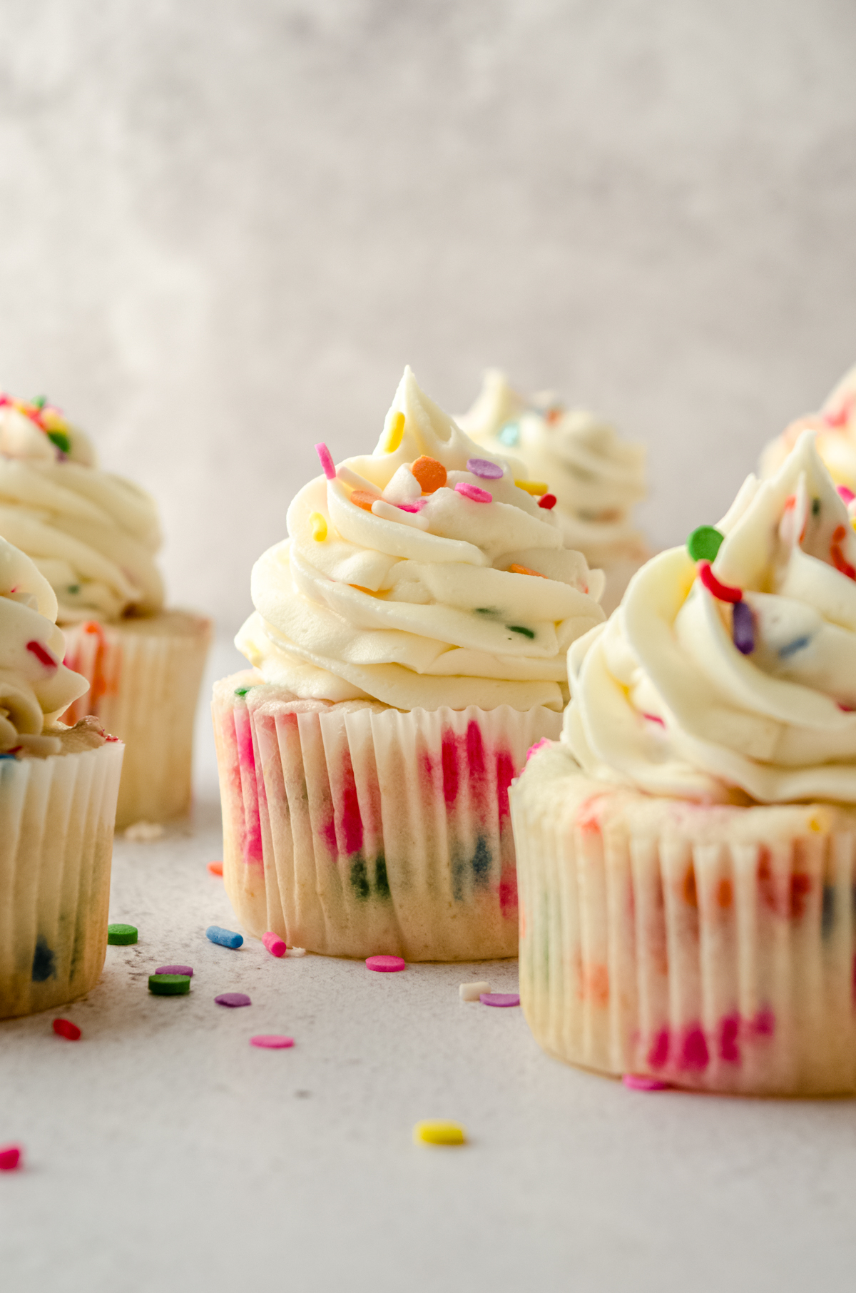 Funfetti cupcakes sitting on a surface.