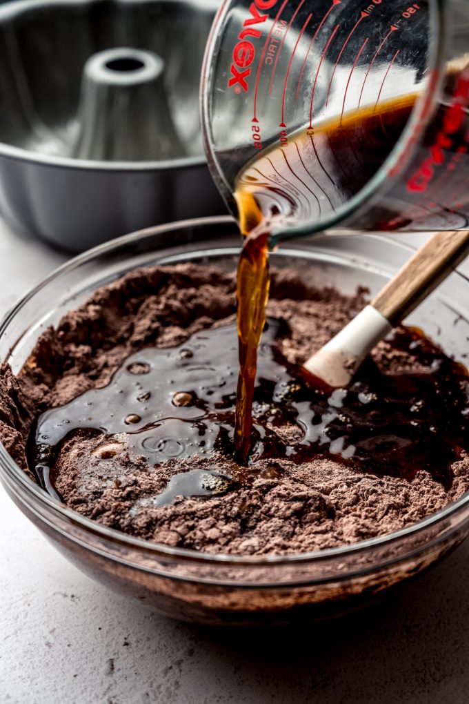 Someone is pouring coffee into chocolate cake batter.