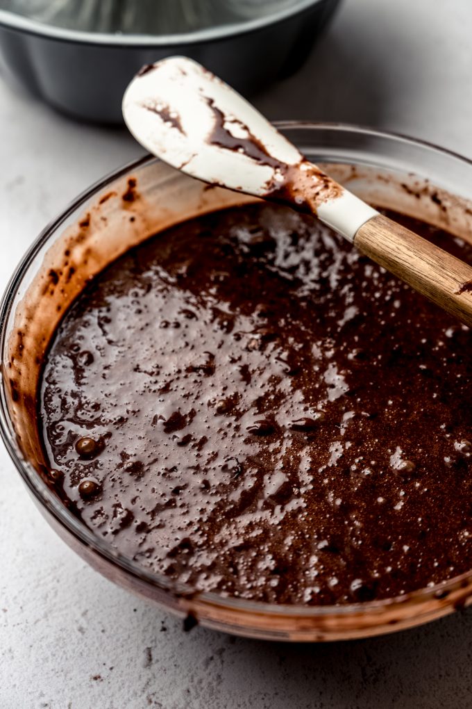 Chocolate bundt cake batter in a bowl with a spatula.
