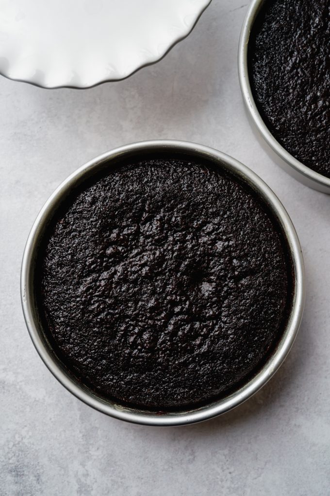 Aerial photo of a layer of baked chocolate cake in a round cake pan.