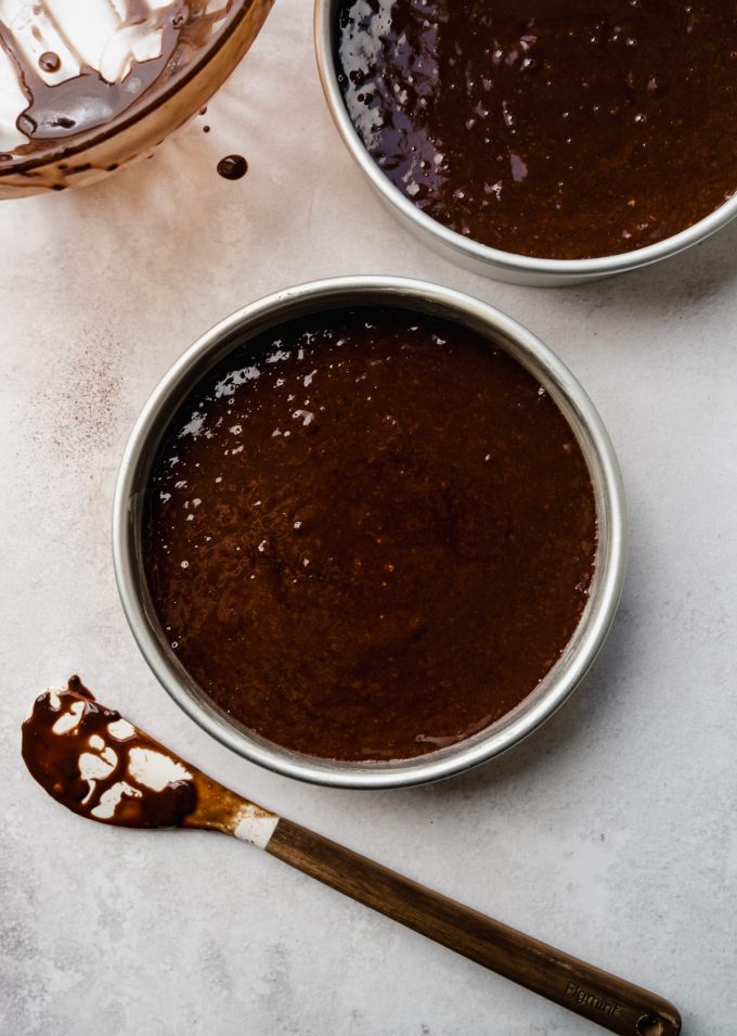 Aerial photo of chocolate layer cake batter in a round cake pan.