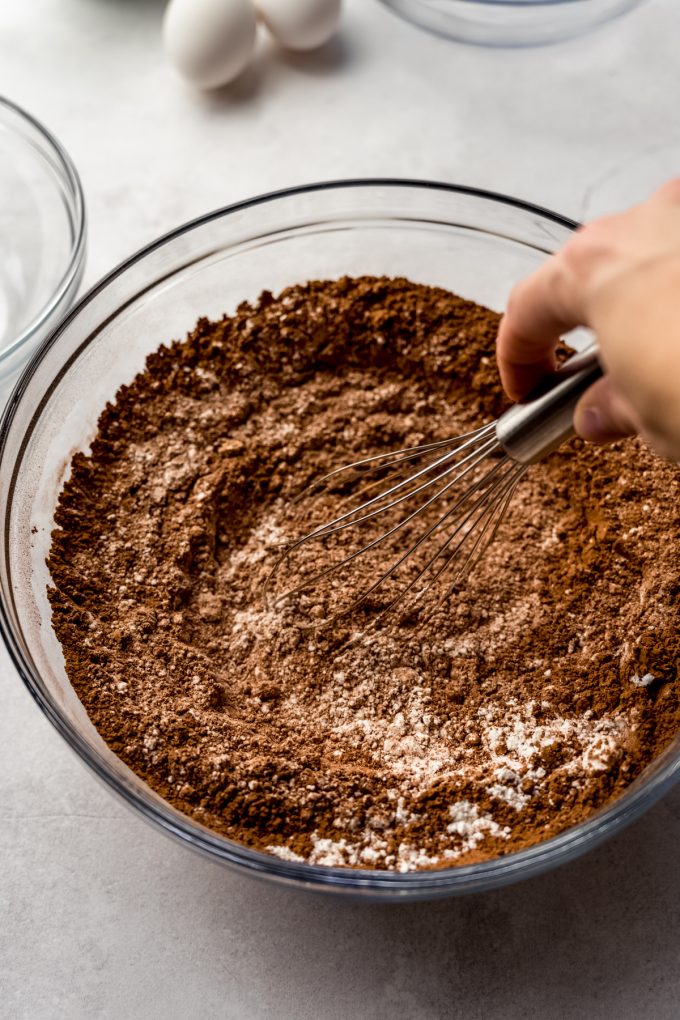 Someone is whisking together ingredients to make chocolate cake.