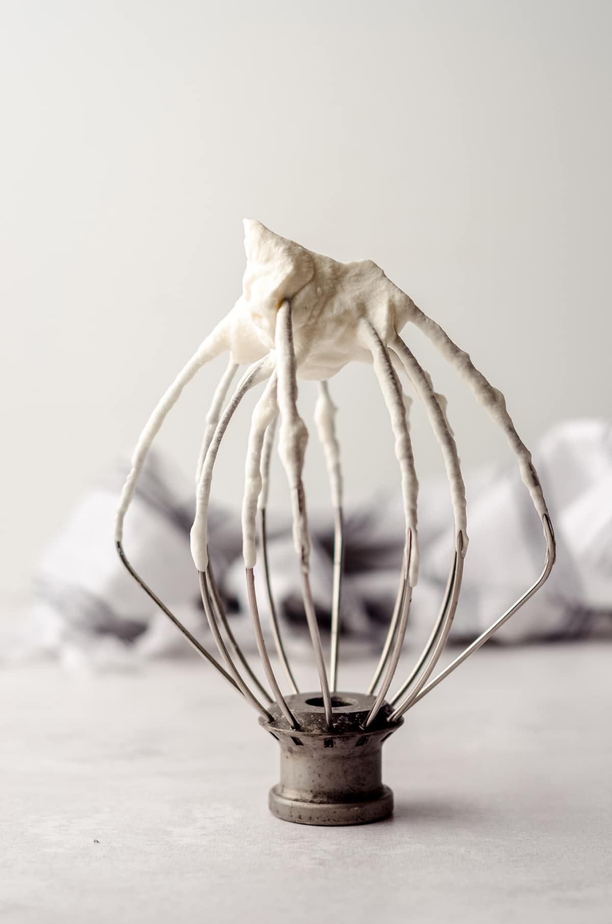 homemade whipped cream on an inverted kitchenaid stand mixer whisk attachment