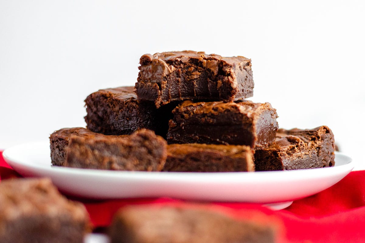 plate of fudgy nutella brownies with one on the top with a bite taken out of it