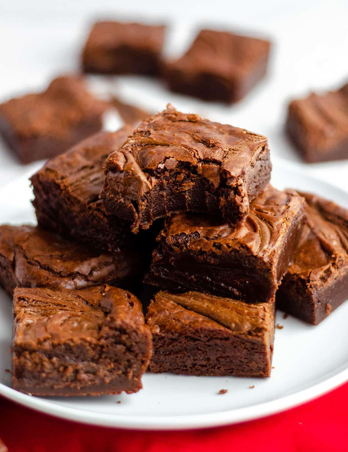 plate of fudgy nutella brownies with one on the top with a bite taken out of it