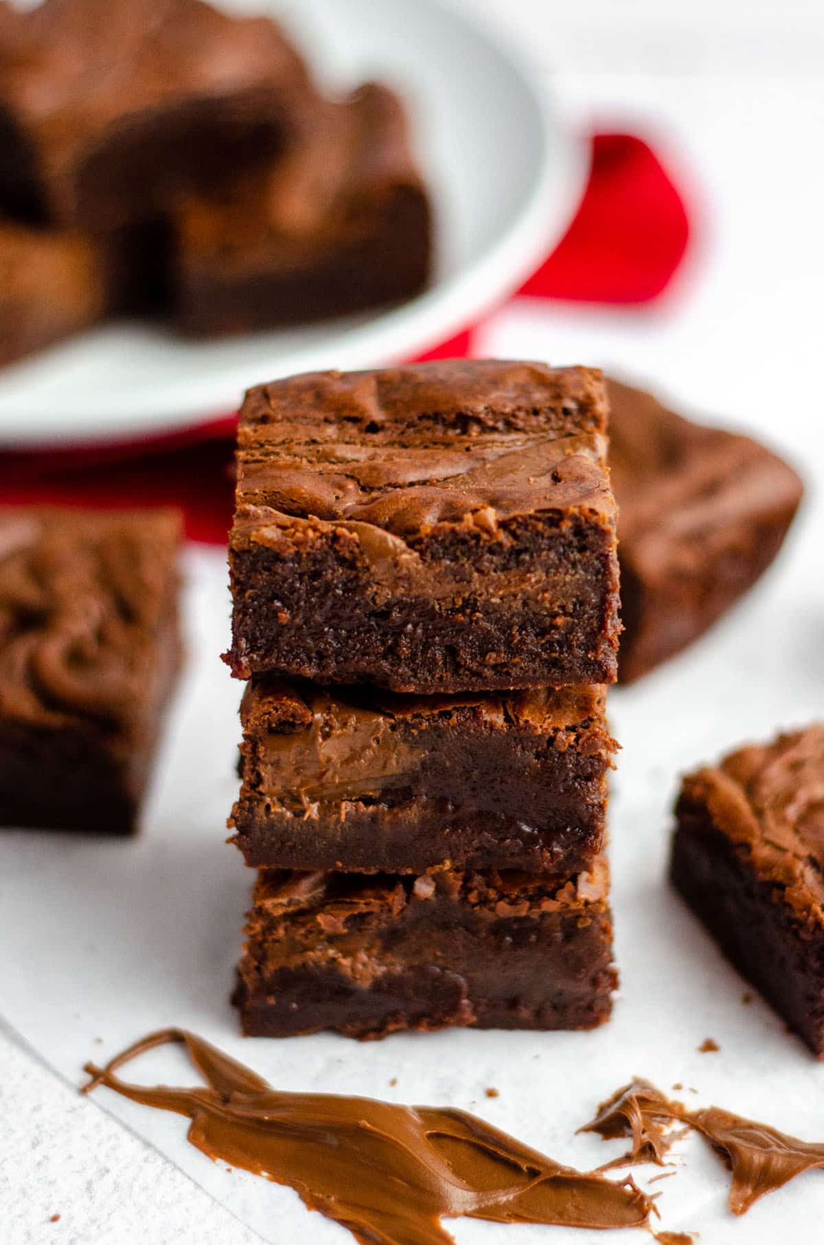 stack of fudgy nutella brownies with a smear of nutella in the foreground