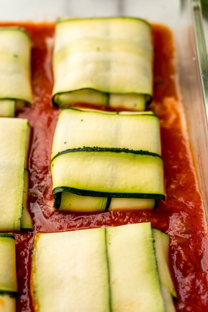 Unbaked zucchini ravioli in a baking dish.