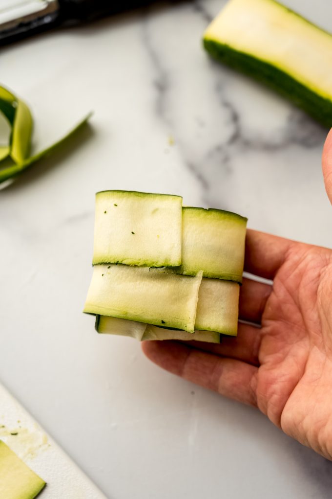 Someone's hand holding a zucchini ravioli pocket.