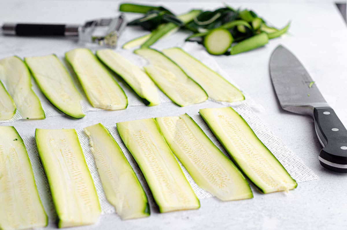 zucchini sliced for zucchini ravioli drying on a paper towel