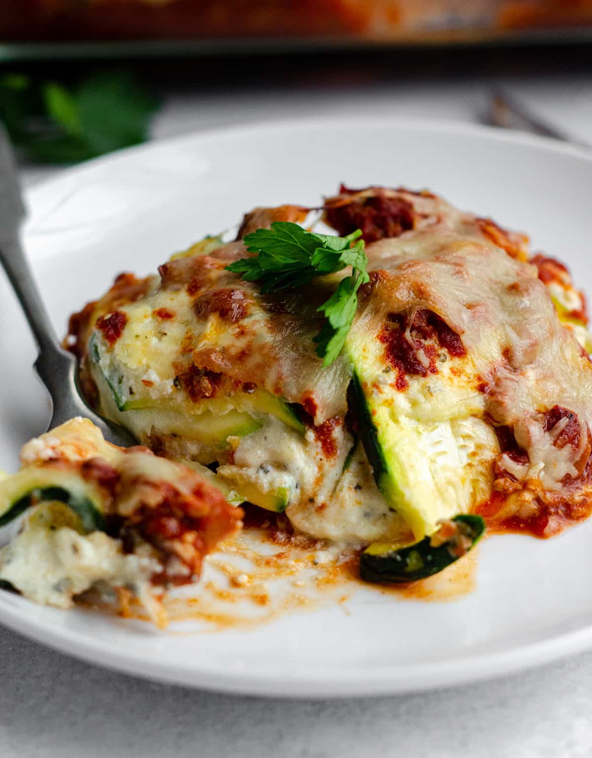 zucchini ravioli sitting on a plate with a fork full of a bite