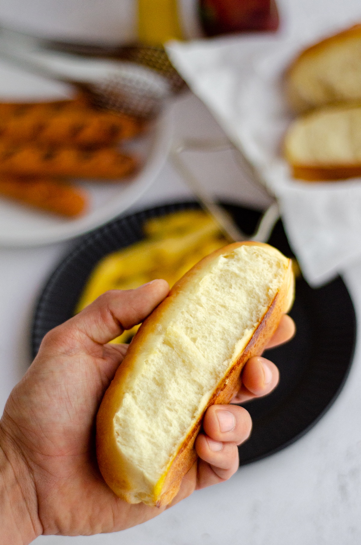 a hand holding a homemade hot dog bun