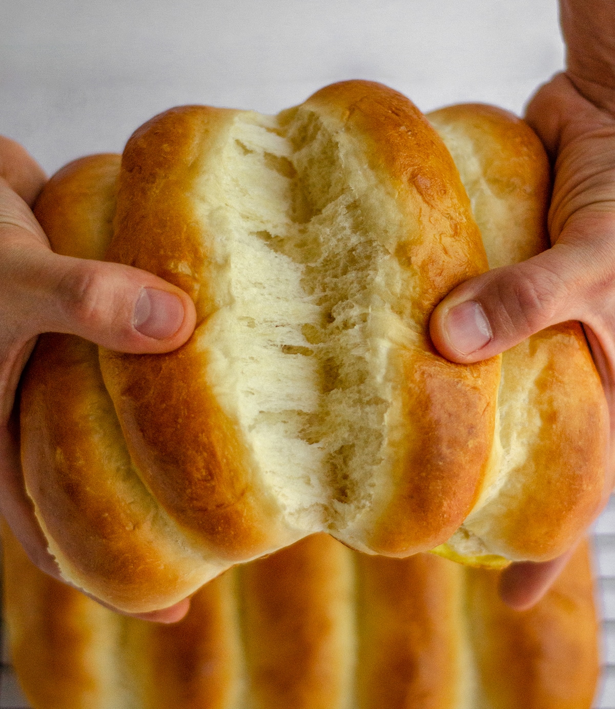 hands pulling apart homemade hot dug buns