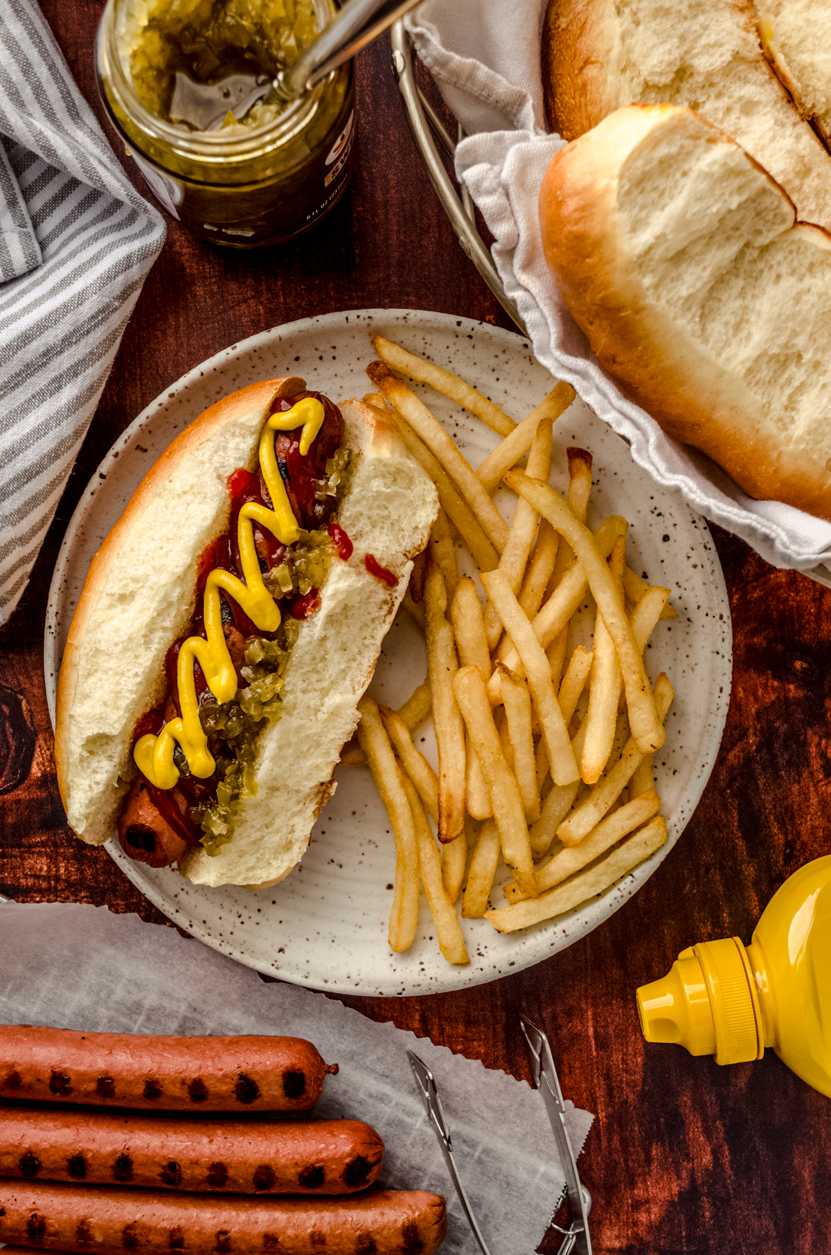 Aerial photo of a hot dog and fries on a plate.