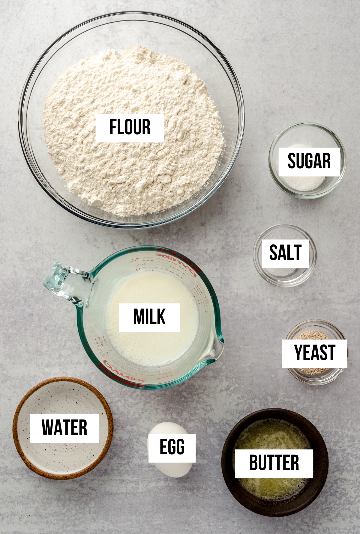 Aerial photo of ingredients for homemade hot dog buns with text overlay labeling each ingredient.