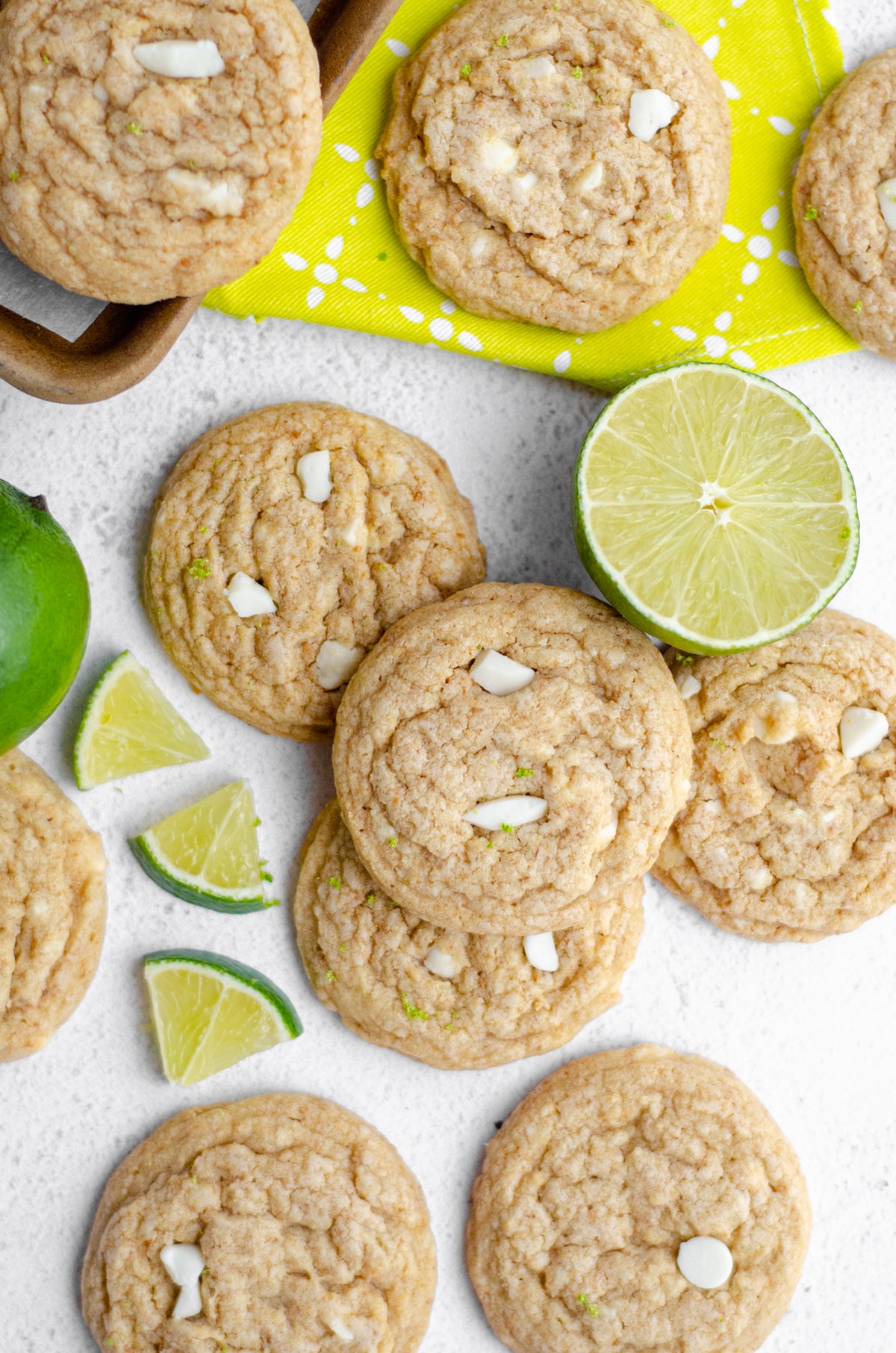 aerial photo of key lime cookies on a white surface with slices of lime around them