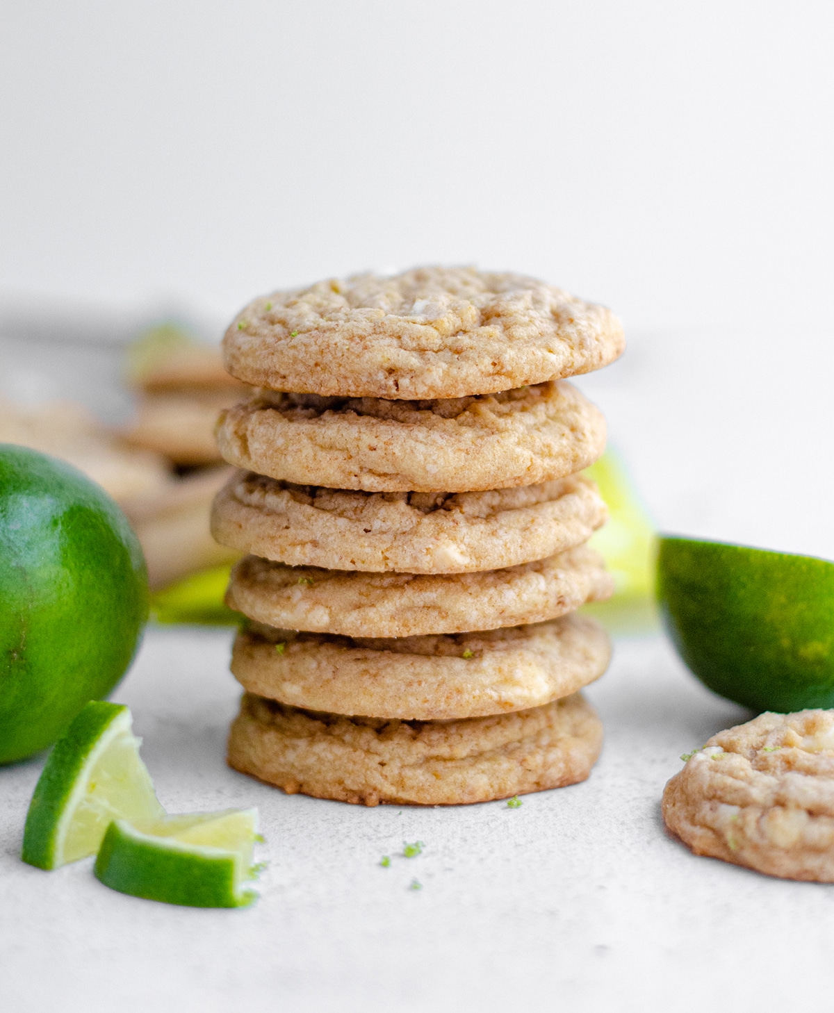 stack of key lime cookies with slices of lime scattered around