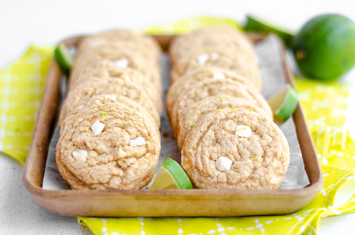 key lime cookies in a serving tray with limes in the background