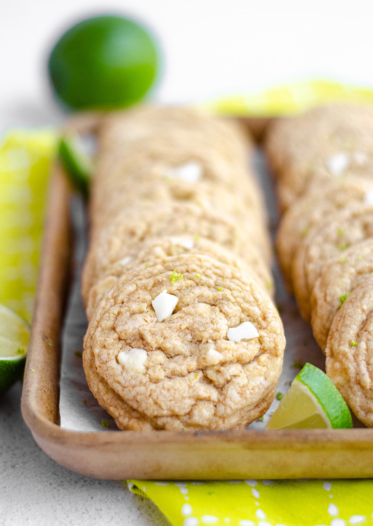 key lime cookies in a serving tray with lime slices scattered around them