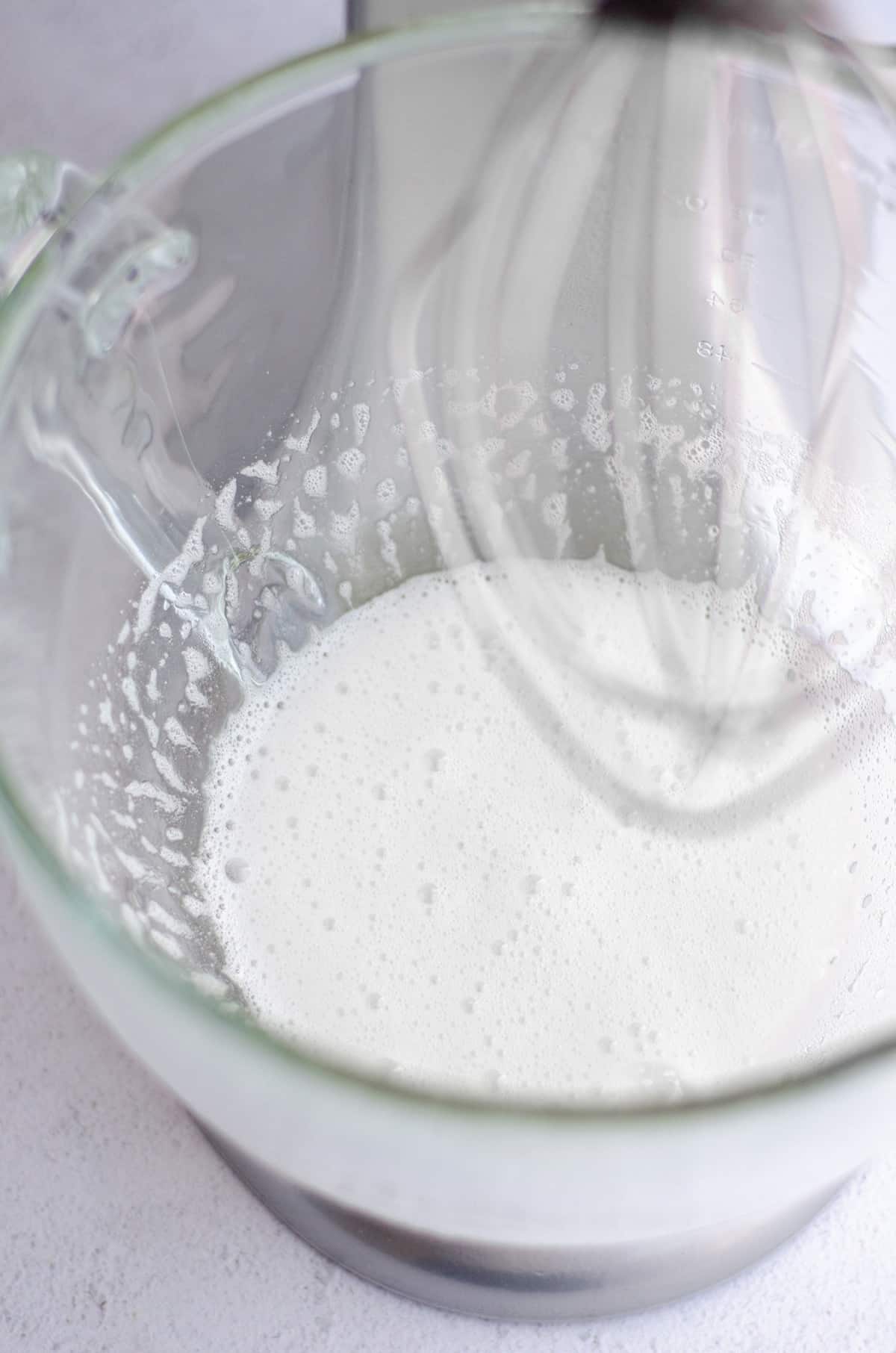 egg whites whipped in a glass mixing bowl for macarons