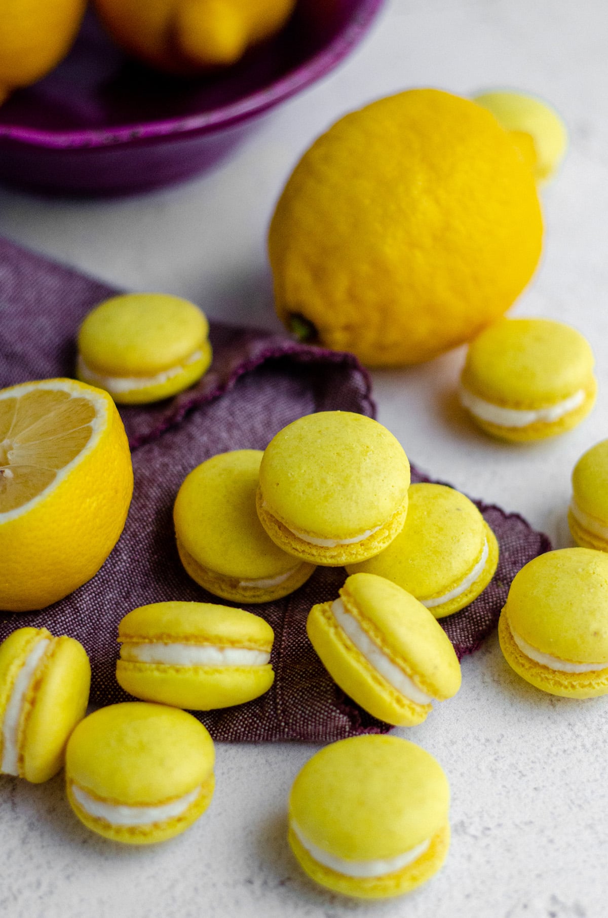 lemon macarons in a group on a purple kitchen towel