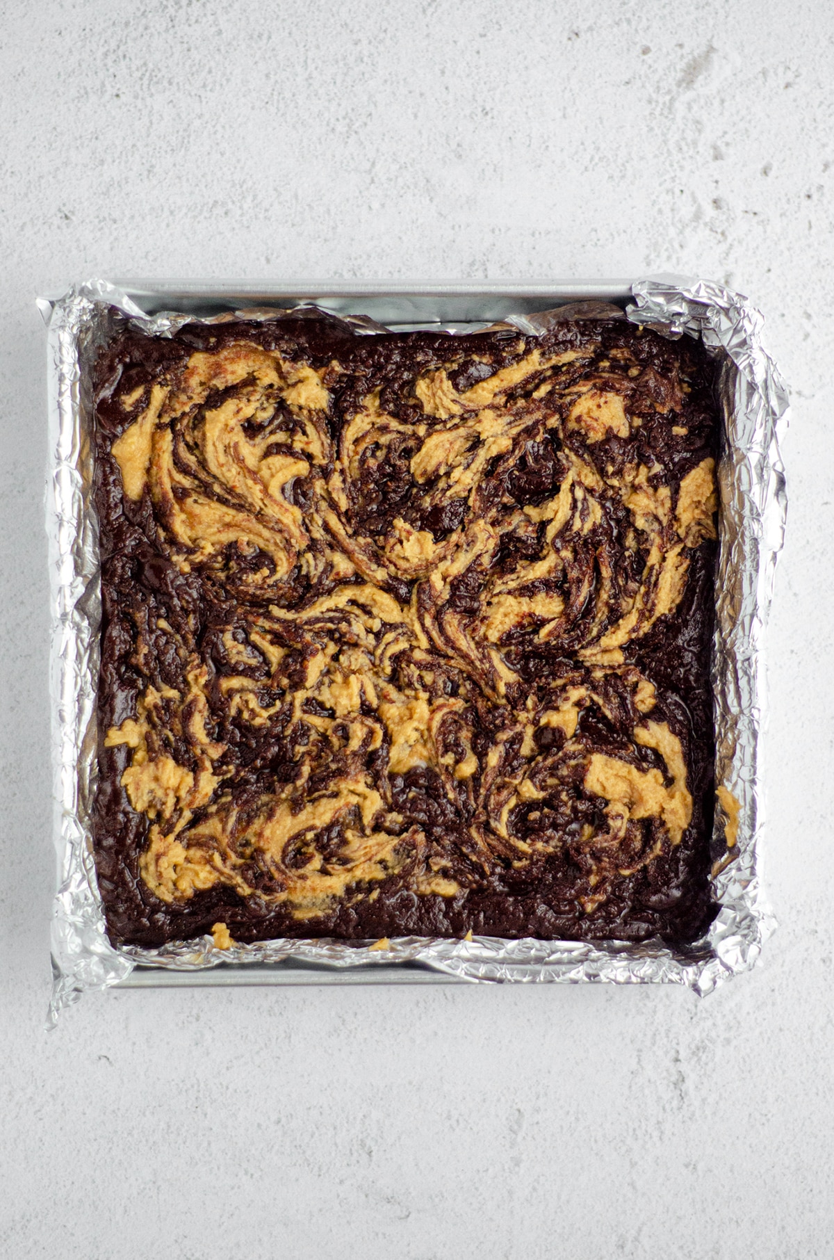 peanut butter cookie batter swirled into brownie batter to make peanut butter cookie brownies 