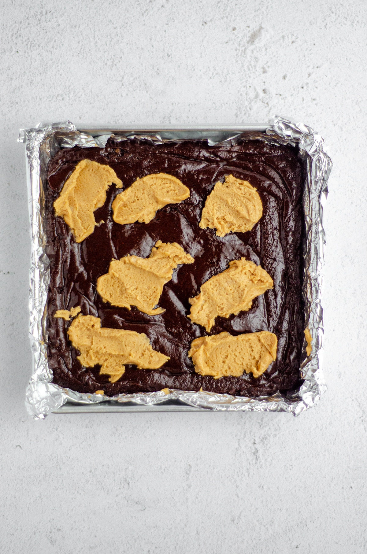 peanut butter cookie dollops on top of brownie batter to make peanut butter cookie brownies 