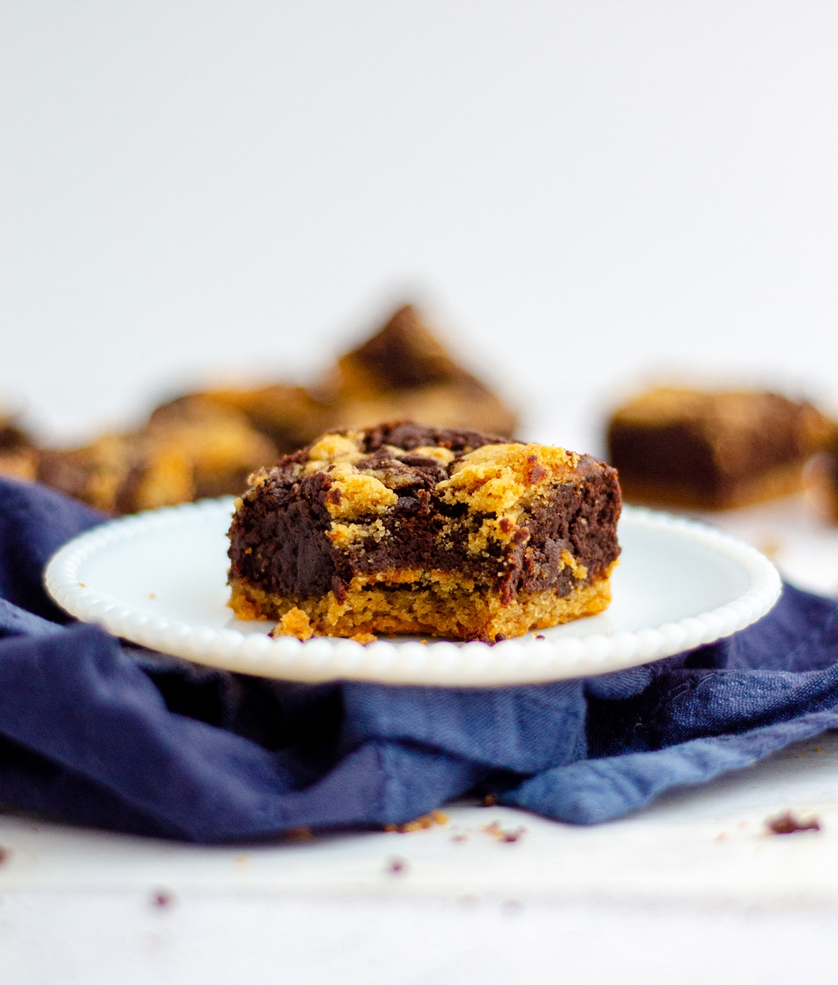 peanut butter cookie brownie sitting on a plate with a bite taken out of it and more brownies in the background