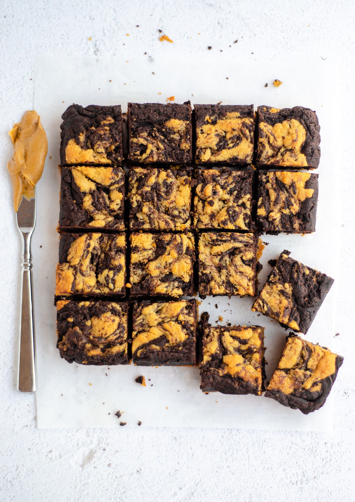 aerial photo of sliced peanut butter cookie brownies with a knife covered in peanut butter next to them