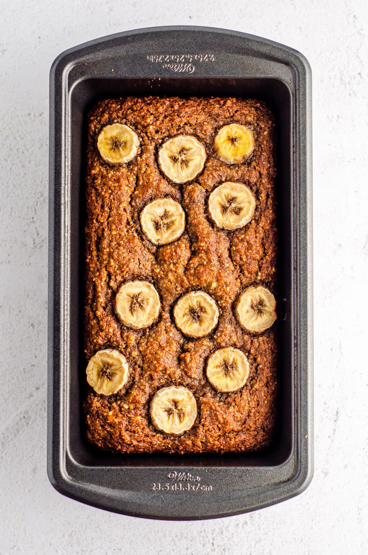 almond flour banana bread baked in a loaf pan with banana slices baked into the top