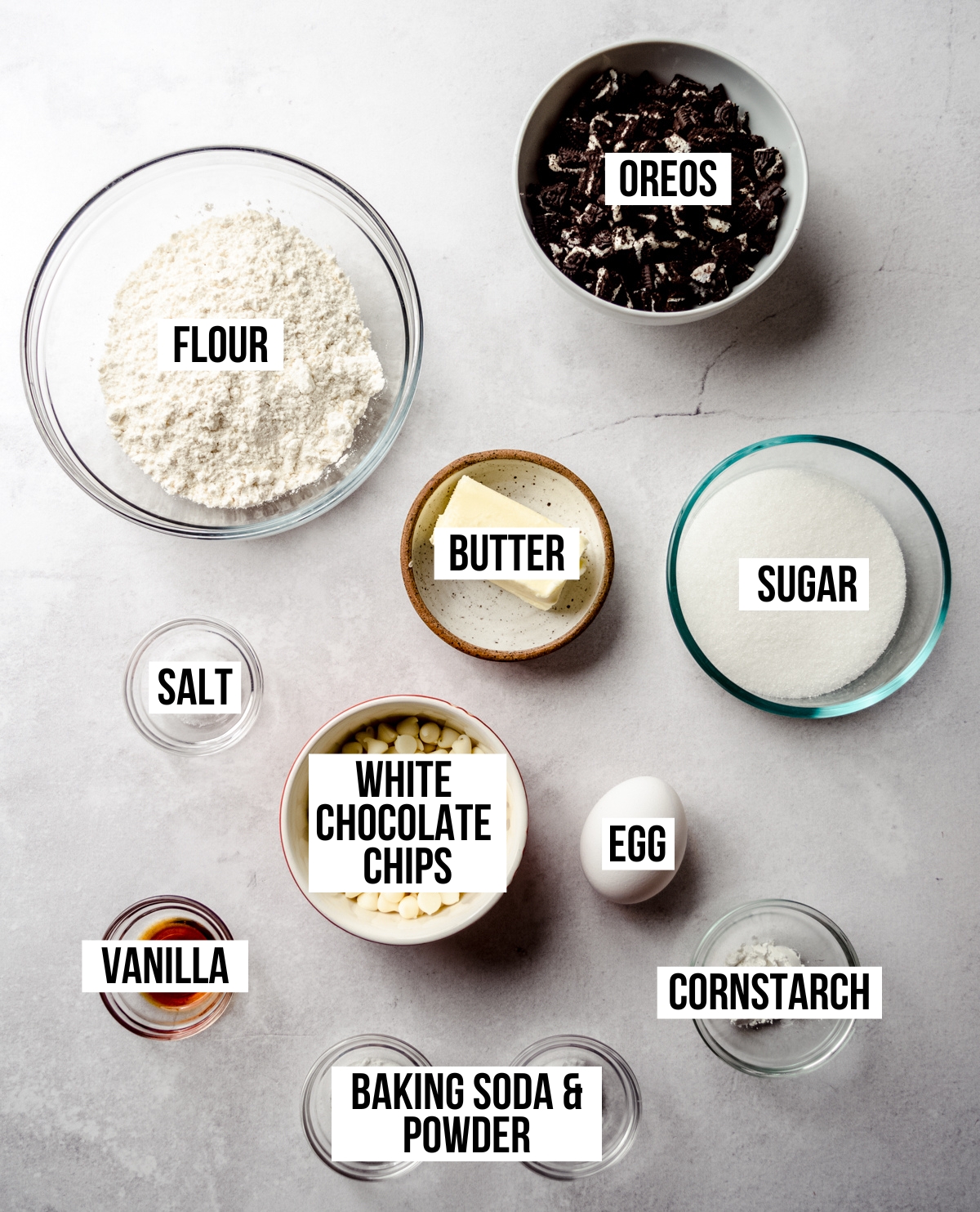 Aerial photo of ingredients to make cookies and cream cookies with text overlay labeling each ingredient.