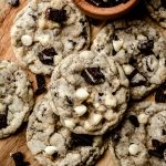 Aerial photo of cookies and cream cookies on a surface with a small bowl of crushed Oreos.