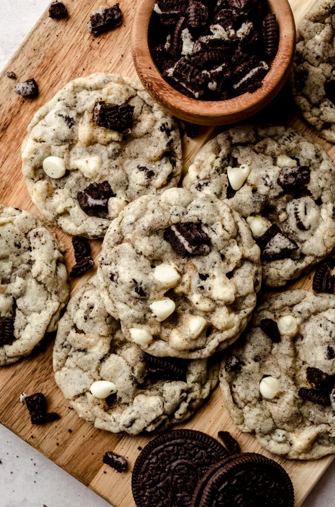 Aerial photo of cookies and cream cookies on a surface with a small bowl of crushed Oreos.