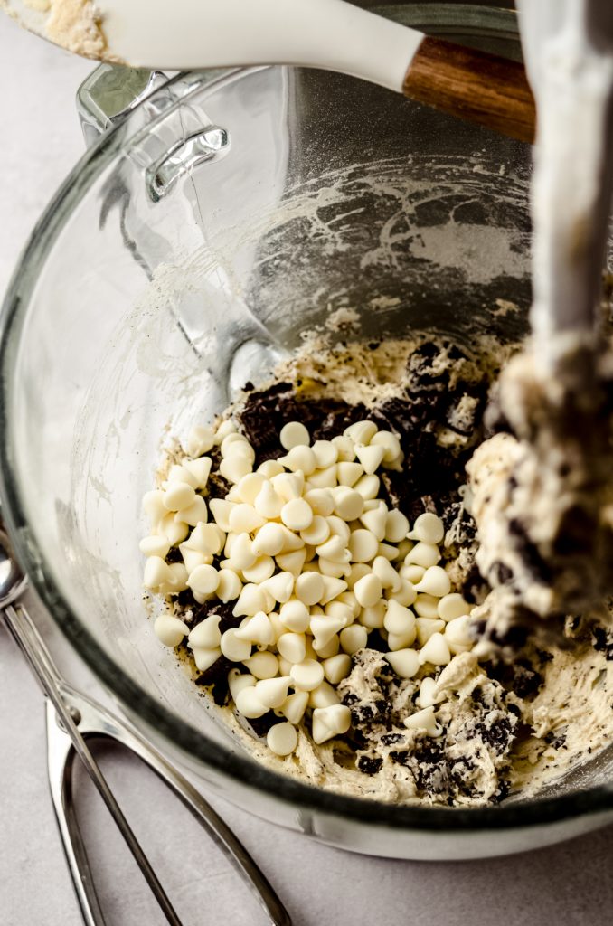 Cookies and cream cookie dough in the bowl of a stand mixer.