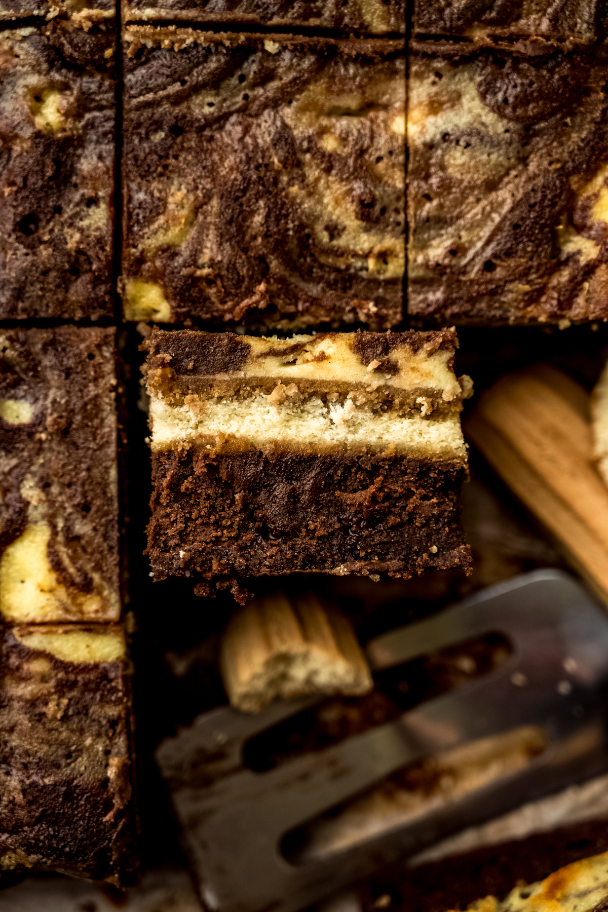 Aerial photo of tiramisu brownies that have been cut and one is facing up so you can see the cross section of the brownie.