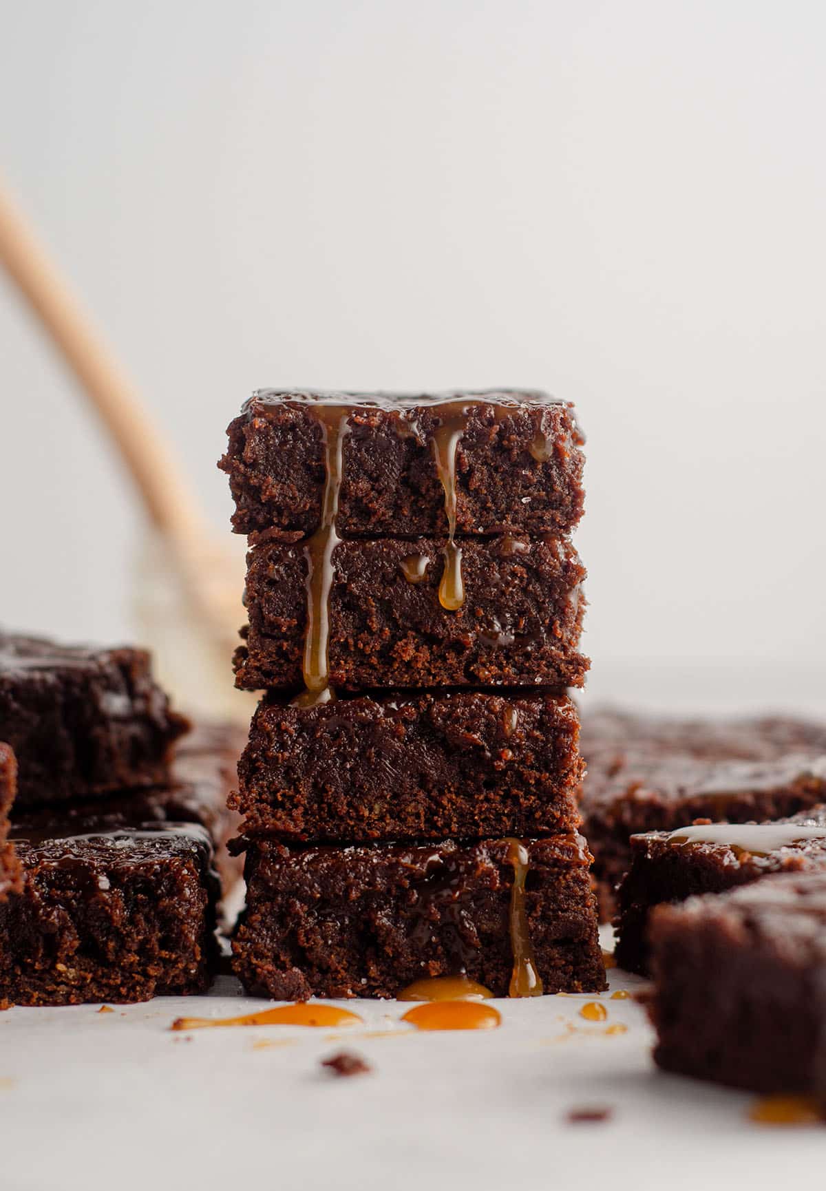 stack of salted caramel brownies with caramel dripping down the stack