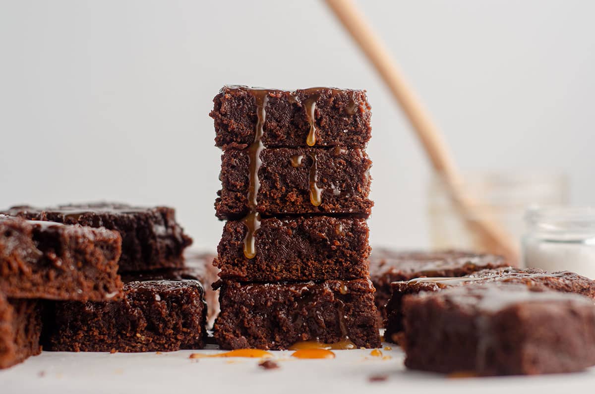 stack of salted caramel brownies with caramel dripping down the stack