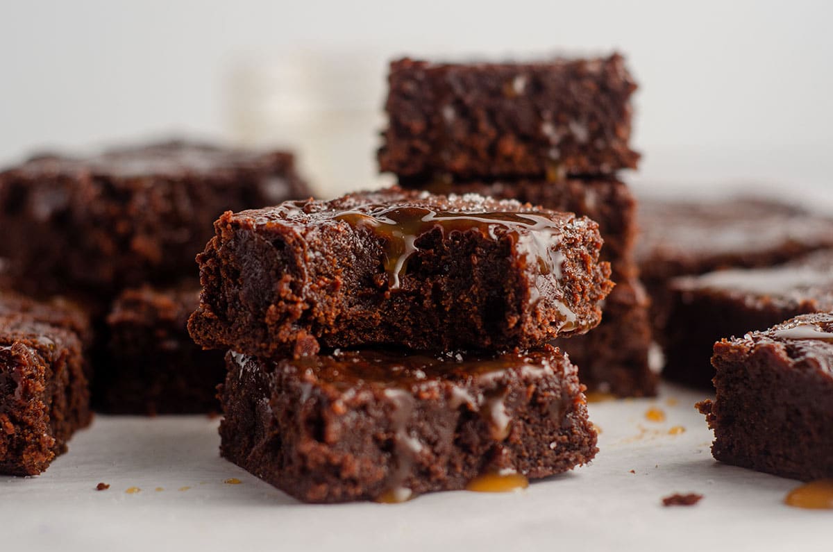 stack of salted caramel brownies with the brownie on top a bite taken out of it