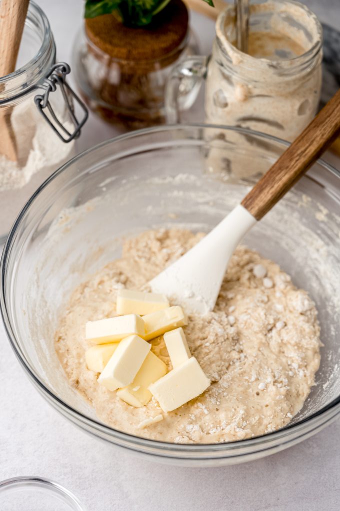 A bowl of sourdough cinnamon roll dough coming together in a bowl with a spatula.