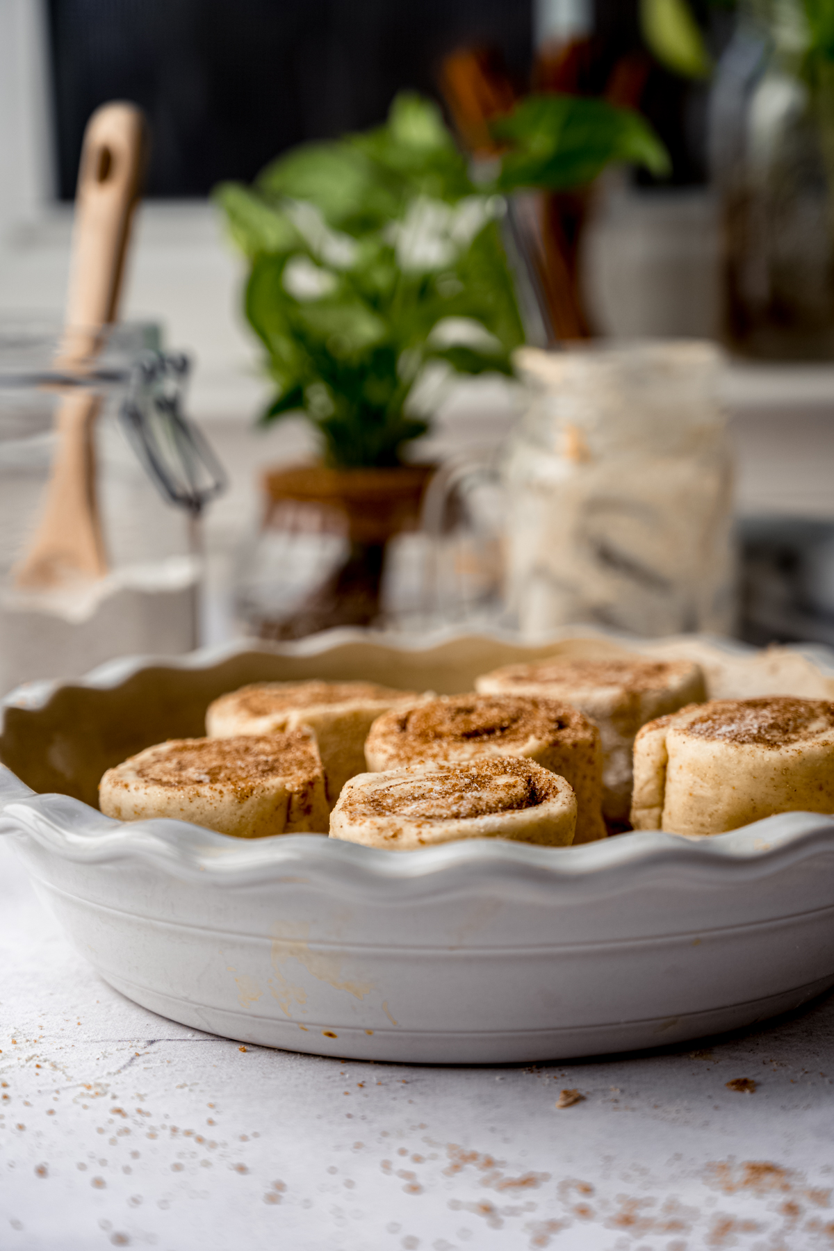 A pie dish with cinnamon rolls in it.