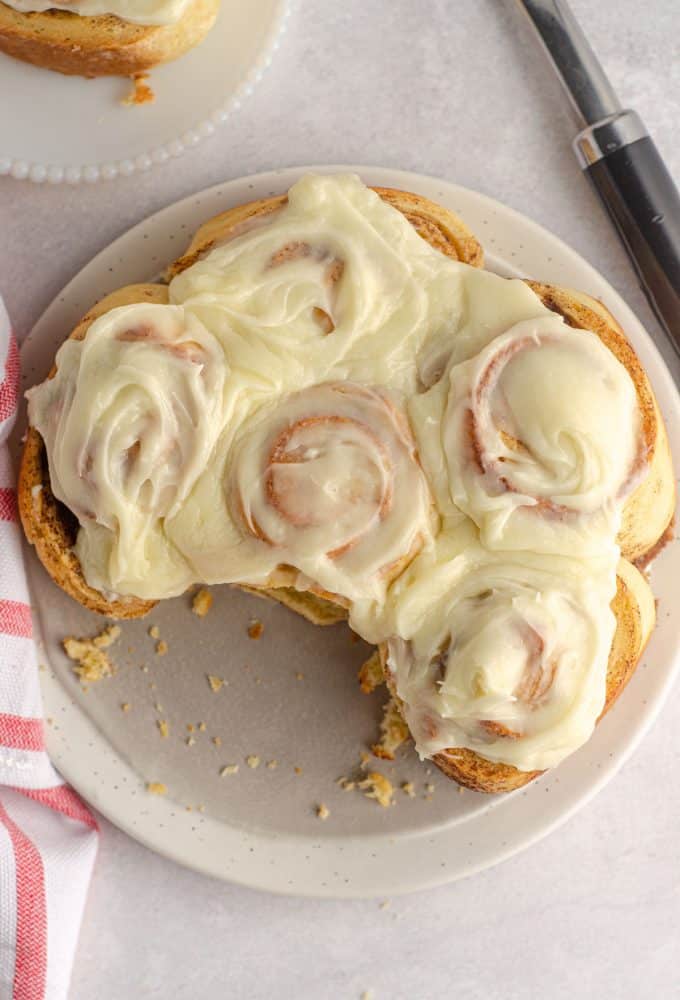 aerial photo of sourdough cinnamon rolls with cream cheese icing on a gray plate