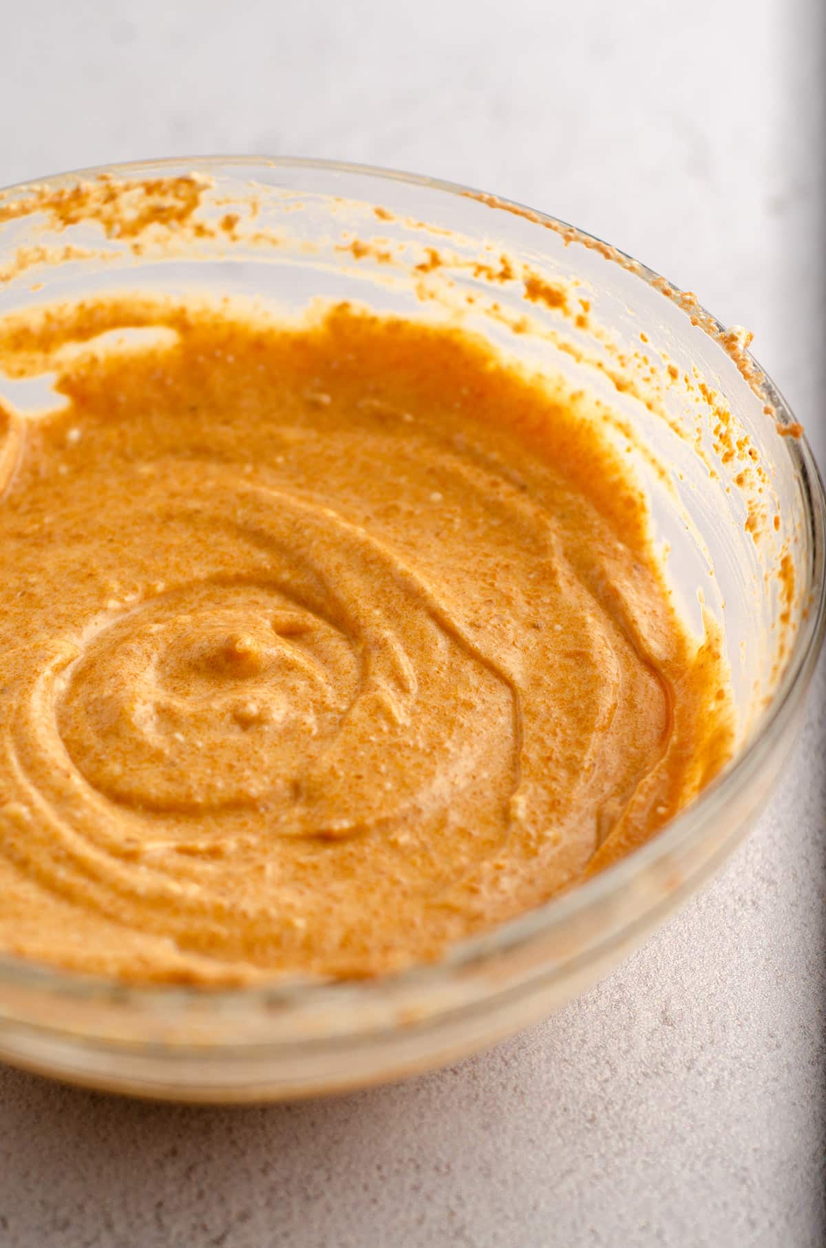 pumpkin batter for pumpkin cheesecake brownies sitting in a glass bowl