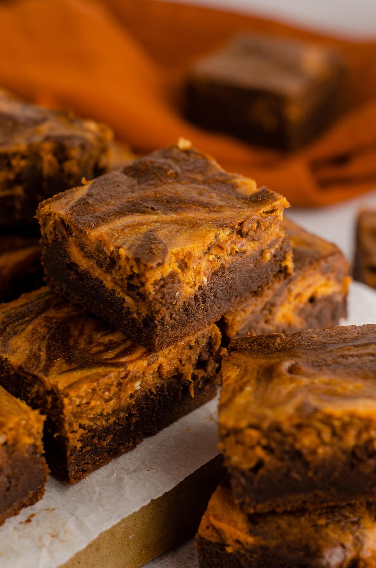 pumpkin cheesecake brownies stacked on a platter