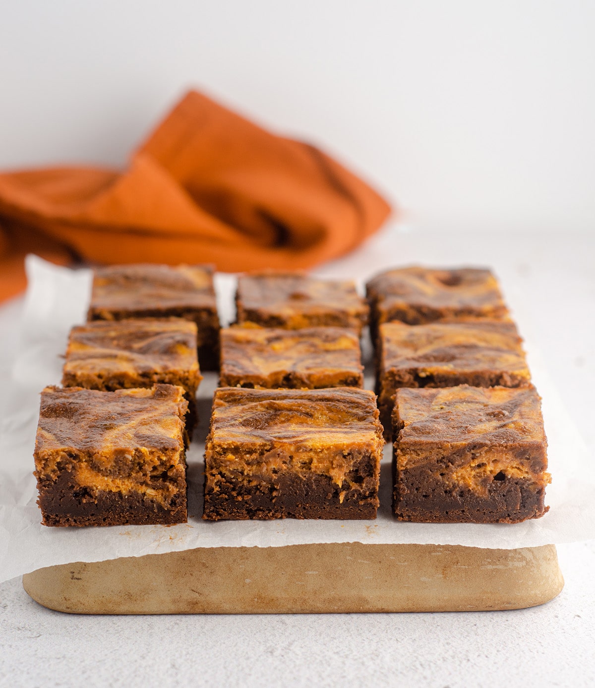 sliced pumpkin cheesecake brownies on a platter