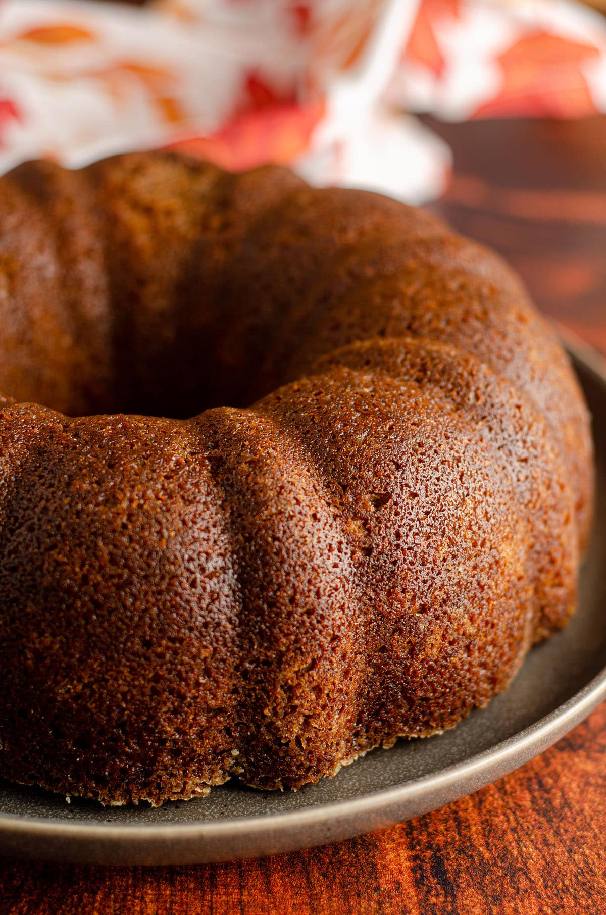 Pumpkin pumpkin bundt cake sitting on a plate without frosting Cake: Moist, spiced bundt cake made with real pumpkin and covered in a decadent brown butter buttercream.