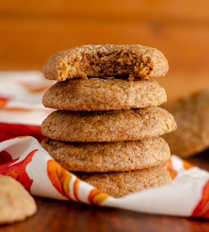 stack of pumpkin spice cookies with a bite taken out of the top cookie