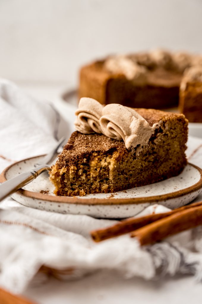 A photo of a slice of snickerdoodle cookie cake on a plate with a fork and a bite taken out of it.