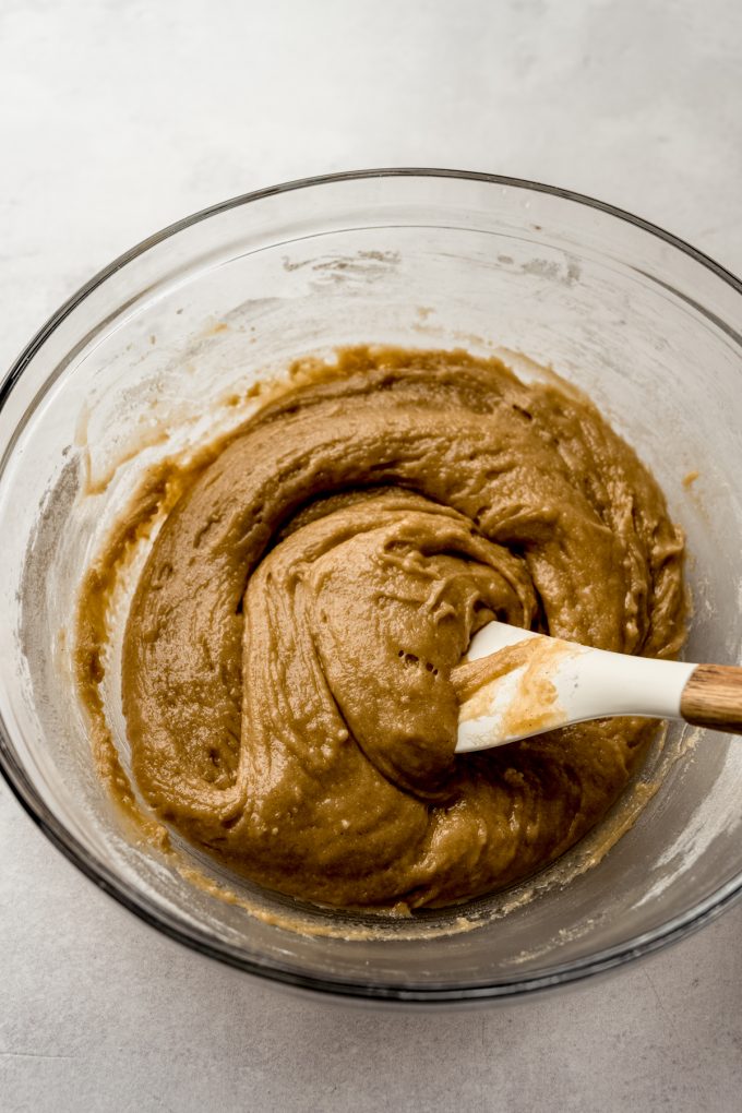 A bowl of snickerdoodle cookie cake batter in a big bowl with a spatula.