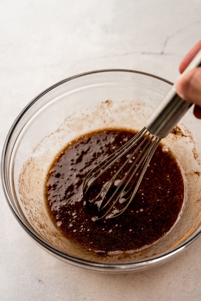 The cinnamon mixture for snickerdoodle cookie cake in a bowl with a whisk.