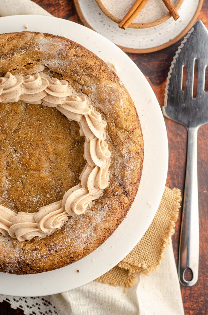 Snickerdoodle Cookie Cake: A simple brown sugar cookie base swirled with cinnamon ribbons and topped with a creamy, spiced snickerdoodle buttercream. Whip up one giant snickerdoodle cookie for your next celebration!